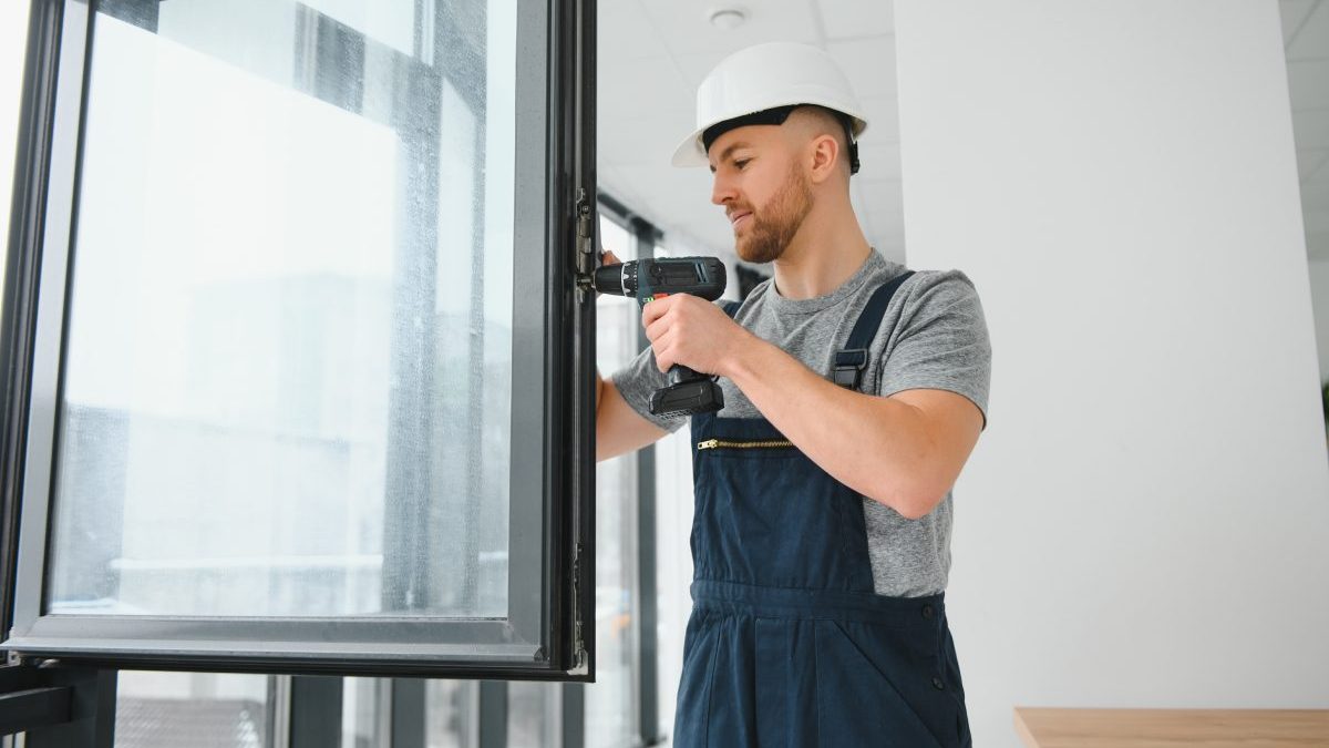 construction-worker-repairing-plastic-window-with-screwdriver-indoors-space-text-banner-design-1-scaled.jpg